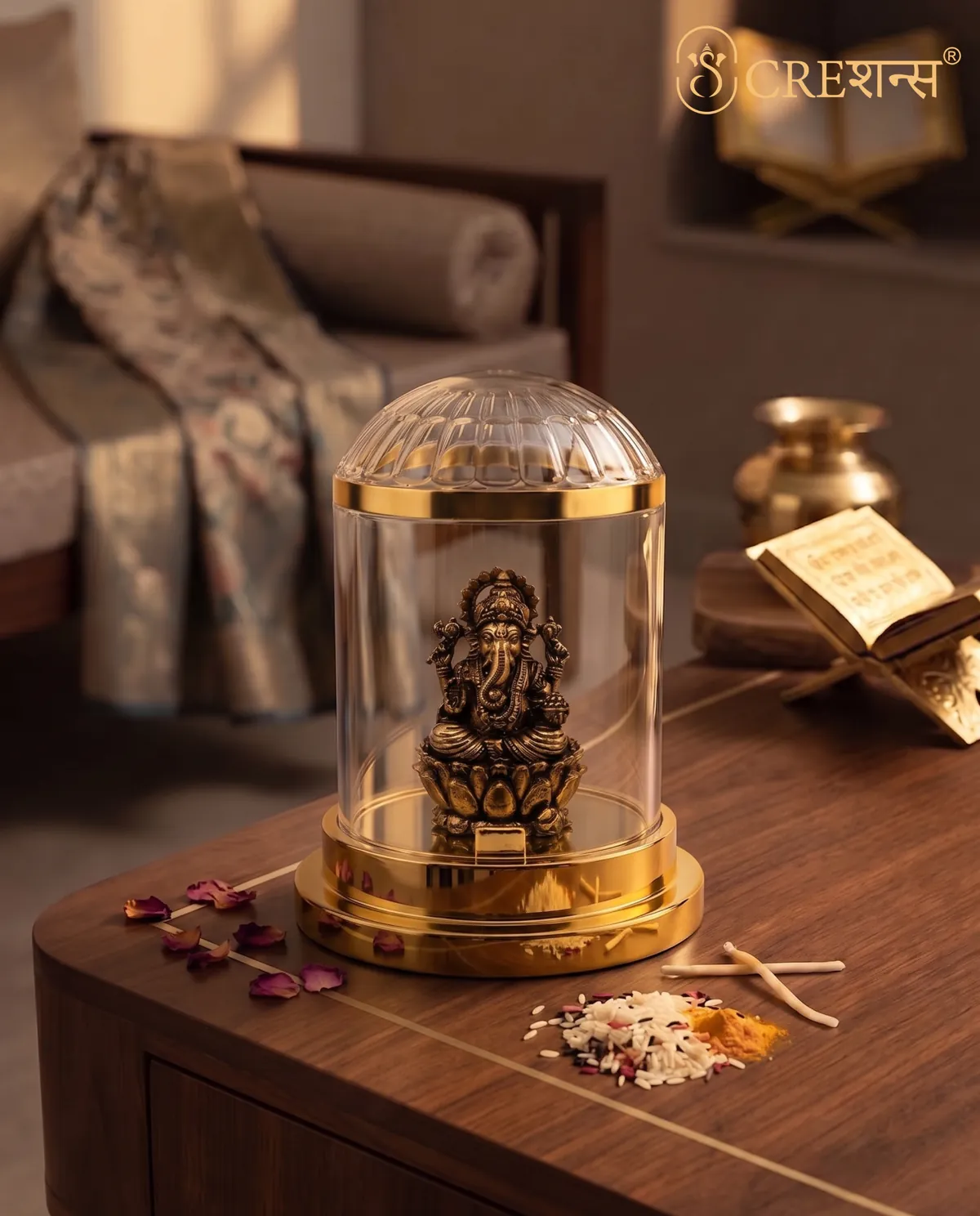 Silver Ganesh cloche on a bedside table with a diya and rose petals