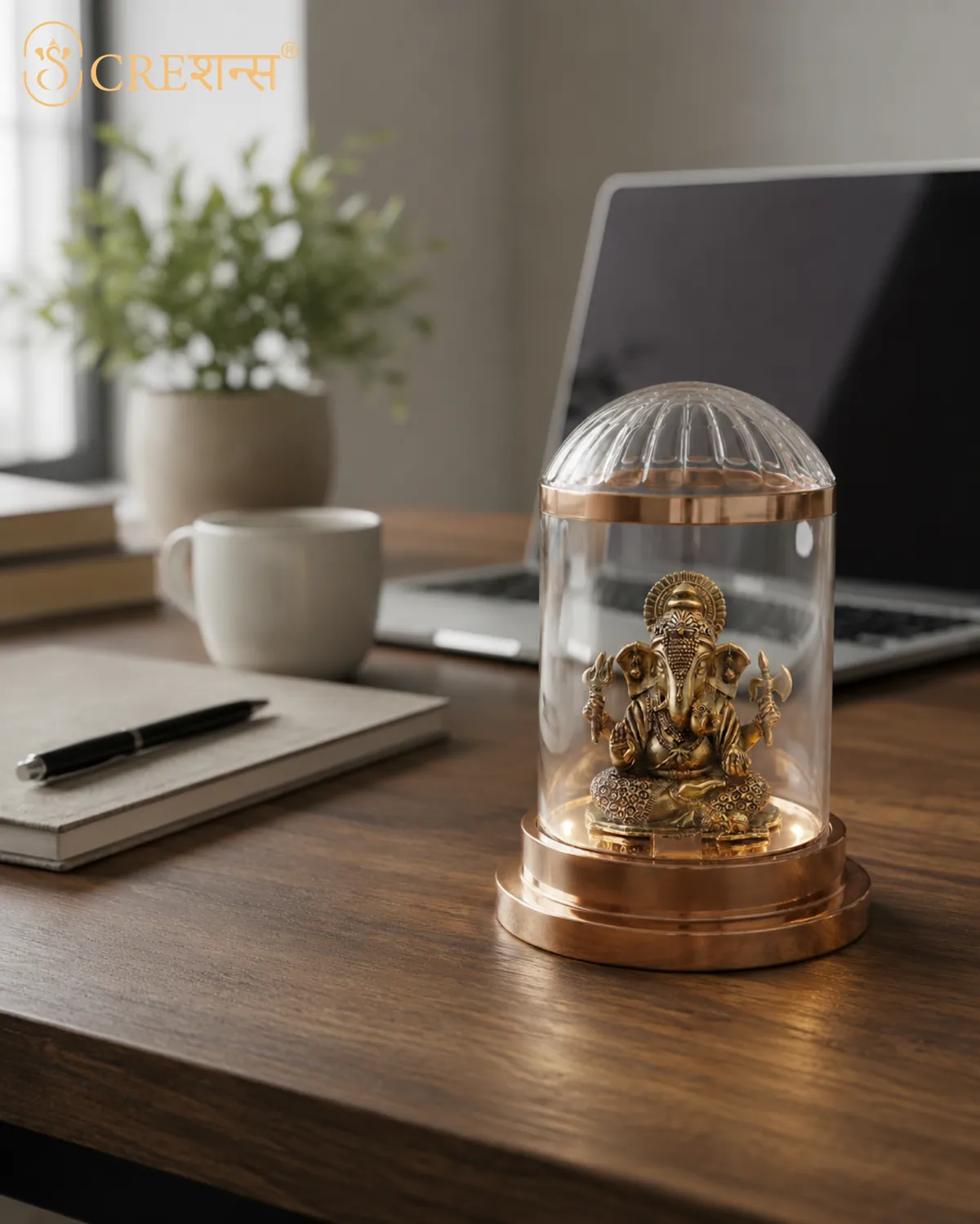 Gold Ganesh cloche on a wooden work desk